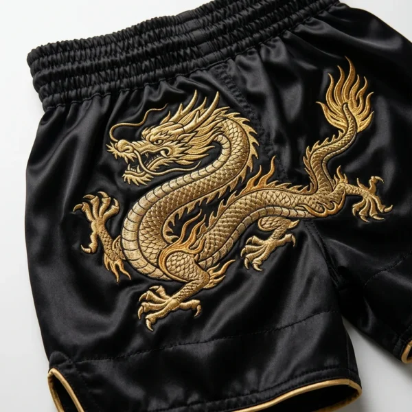 Black boxing shorts with gold embroidered dragon close up