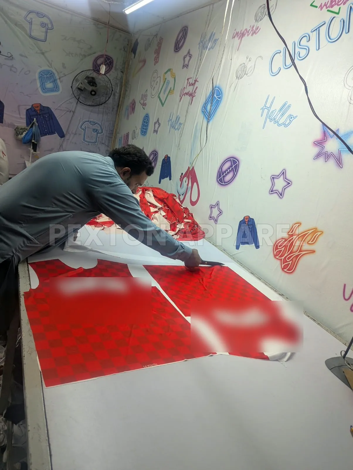 Laying sublimated jersey panels out for cutting at Pexton Apparel