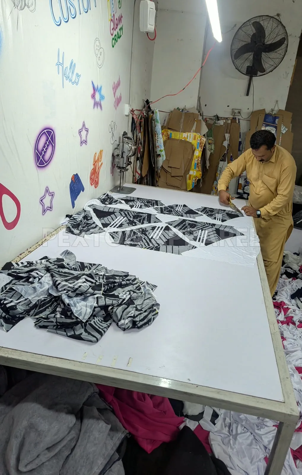 Cutting printed sublimation fabric into garment panels at Pexton Apparel